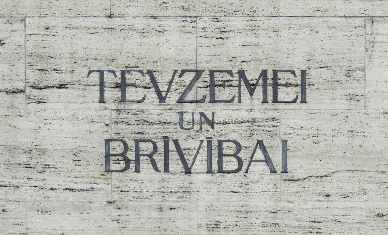 The inscription ‘For Fatherland and Freedom’ by Kārlis Skalbe, placed on the front of the monument as its core dedication.