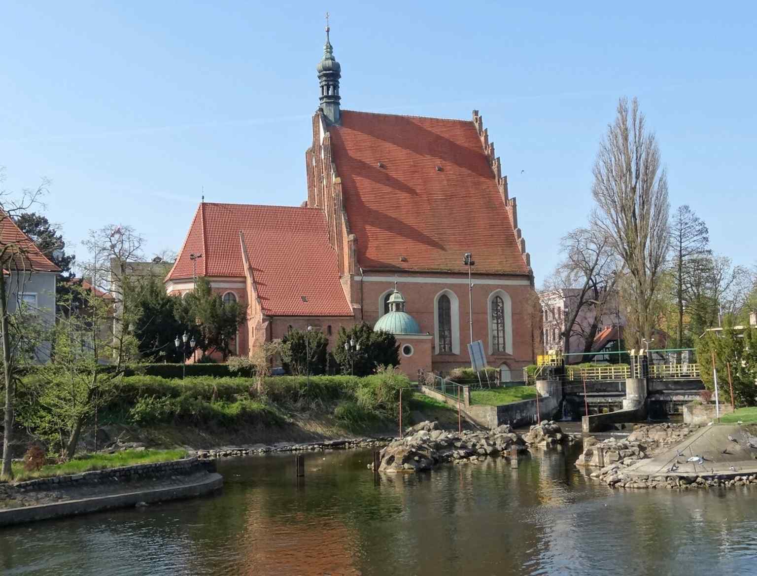 The cathedral from the Brda side with the sanctuary name in view, fitting the story of its riverside setting and Marian cult.