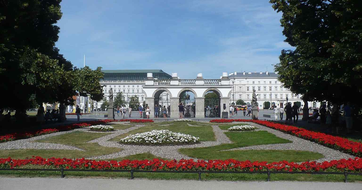 A wider exterior view of the monument on Piłsudski Square, useful for showing the surviving arcade fragment of the former Saxon Palace colonnade.