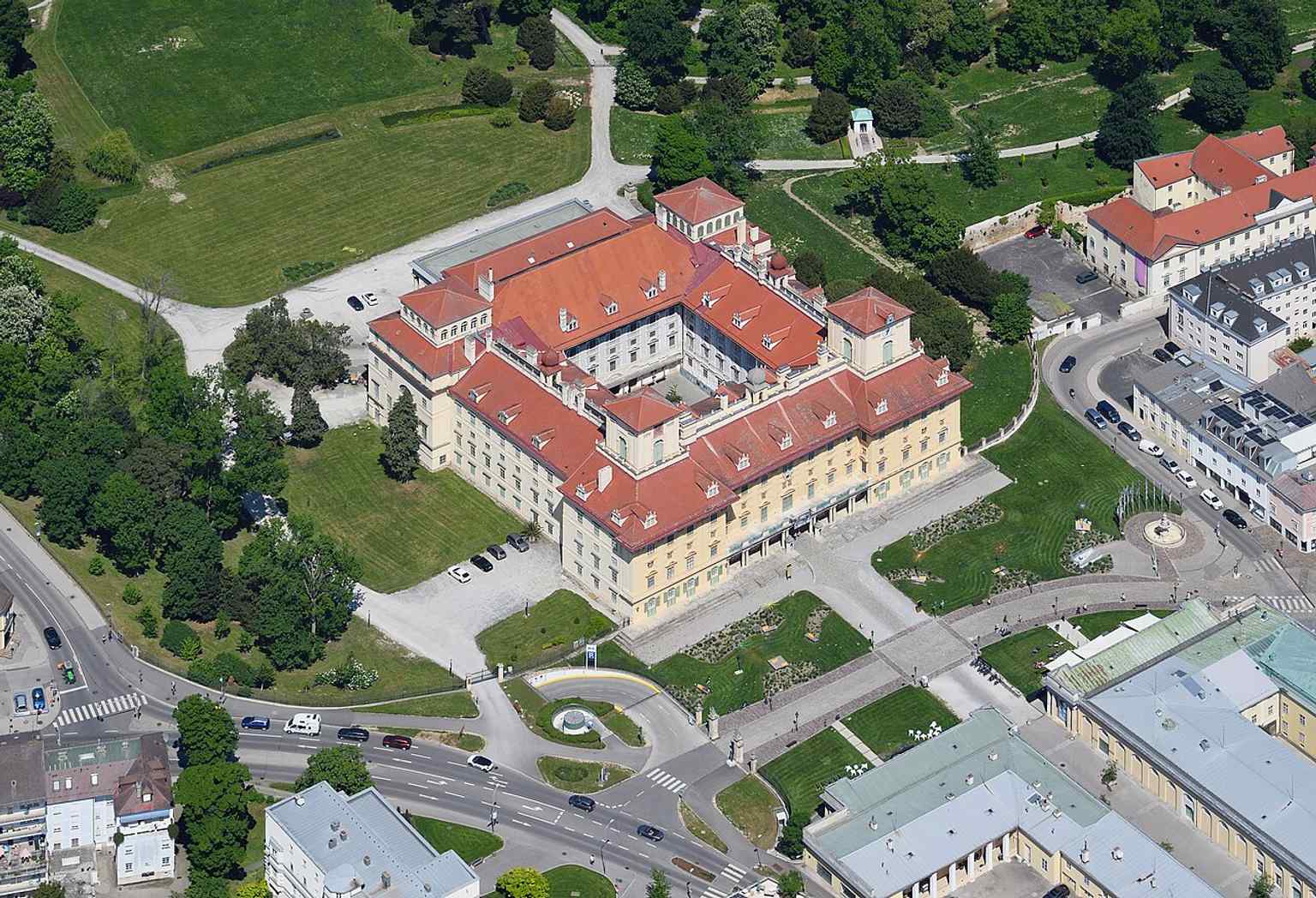 A clear aerial view from the south showing the palace and its long classical footprint, shaped by the unfinished 19th-century redesign.
