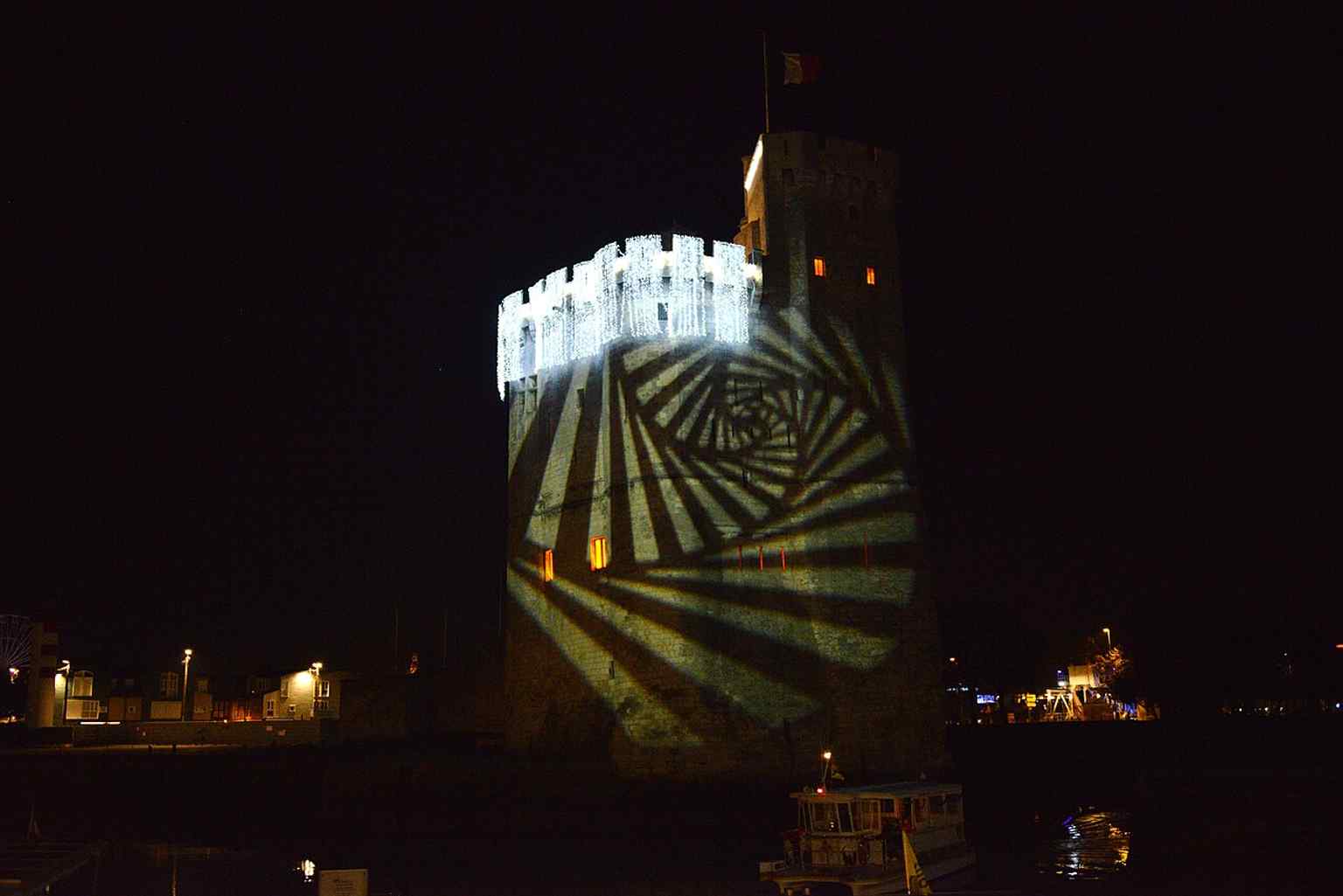 Saint Nicholas Tower illuminated for the year-end festivities, a contemporary night view that contrasts with its centuries of military use.