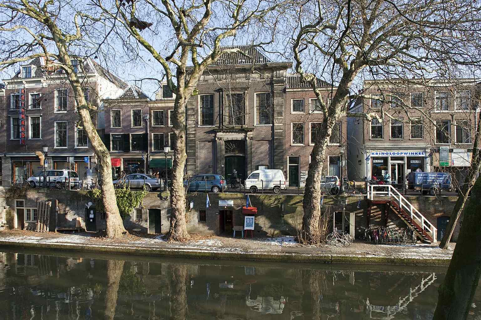 A wider exterior view of the church's west facade on the Oudegracht, illustrating its integration with the surrounding medieval canal houses.