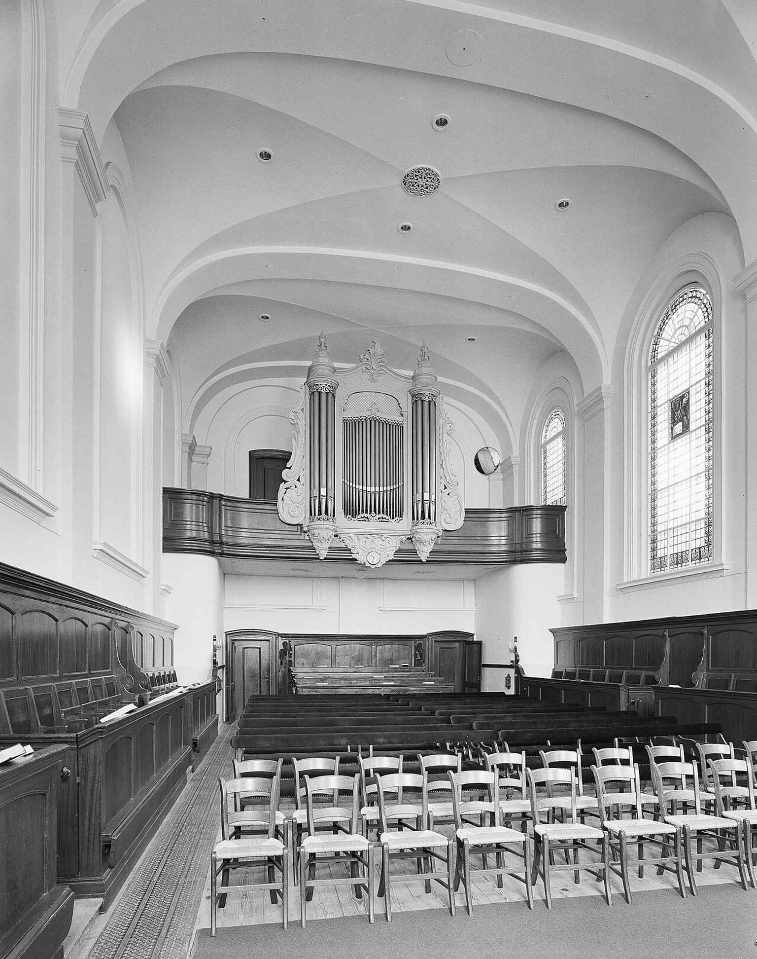 The elegant interior view towards the west, featuring the pews and the Bätz organ. This perspective likely includes the 'remarkable yellow windows' installed in 1922.