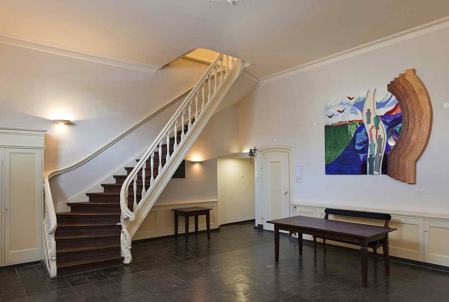 The church's entrance hall on the ground floor with a staircase leading to the first floor, reflecting the building's origin as a converted medieval canal house.