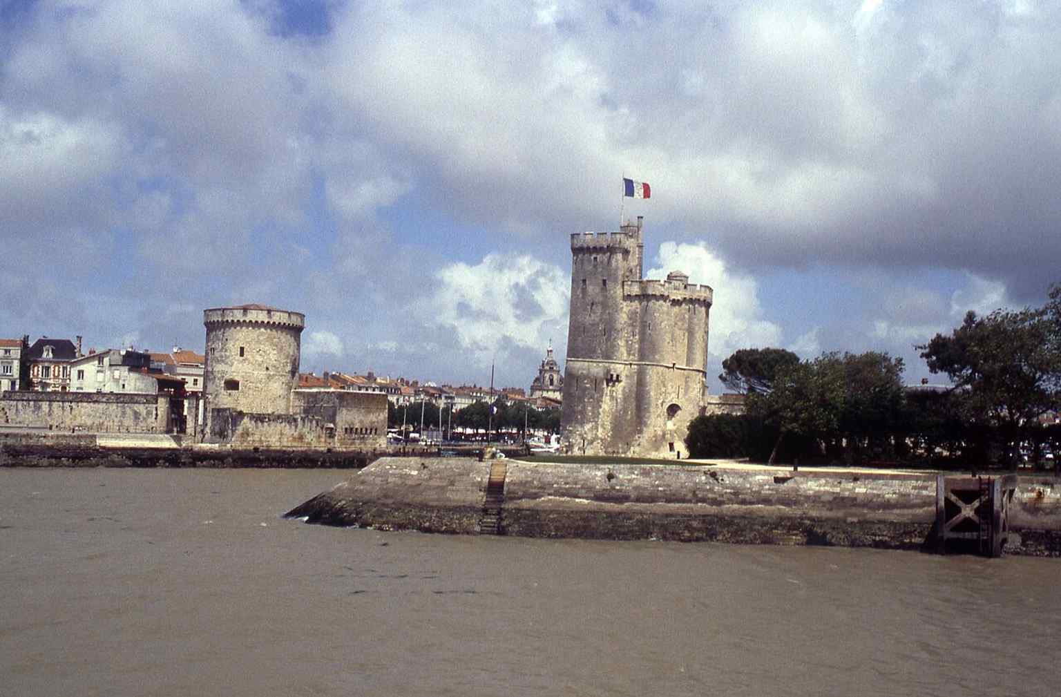 A historic photo of the harbor entrance, showing the Chain Tower in its everyday setting before the current visitor experience.