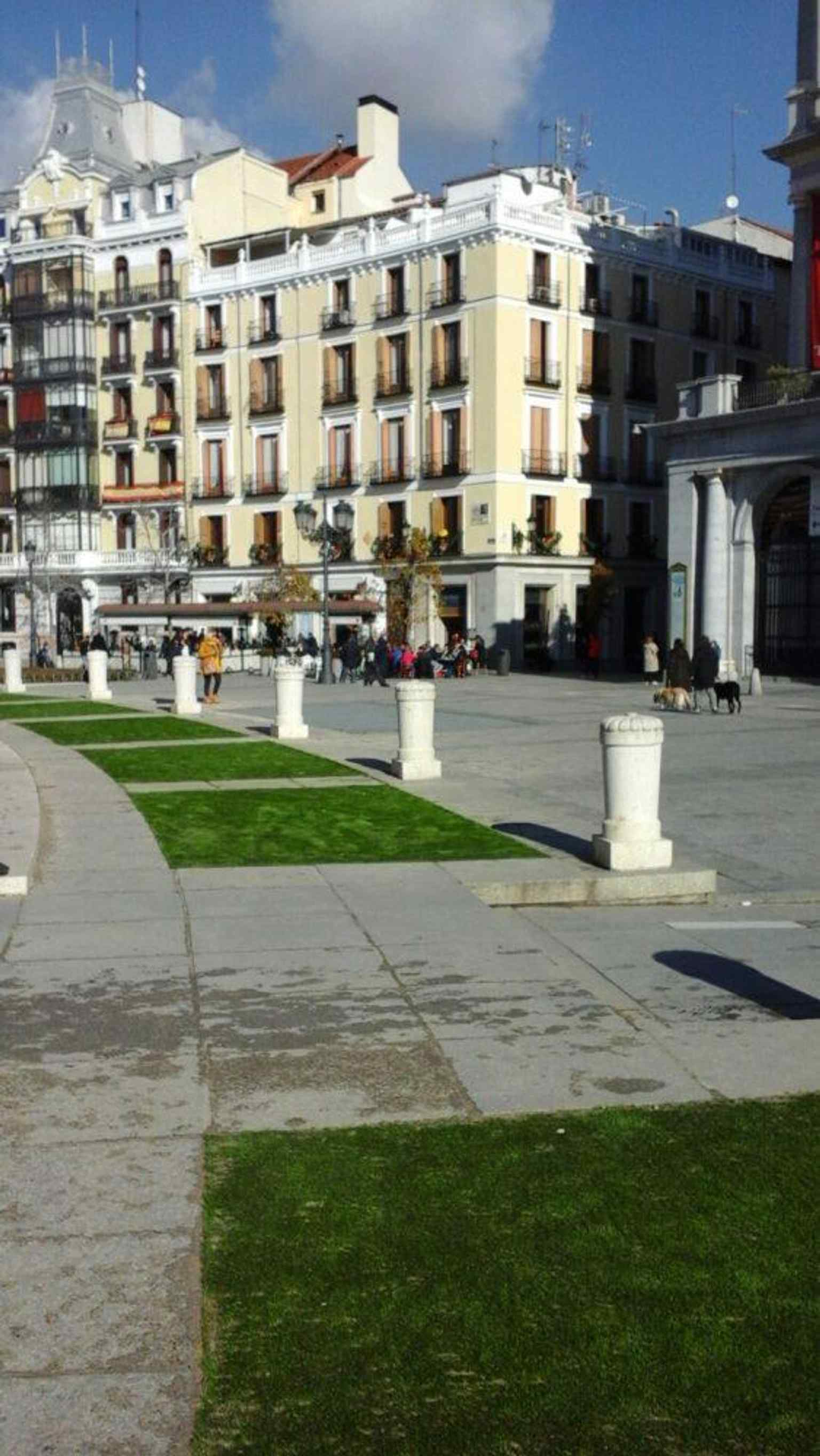 Modern artificial turf in the parterres shows how the plaza’s gardens have been adapted to stay green in low light.