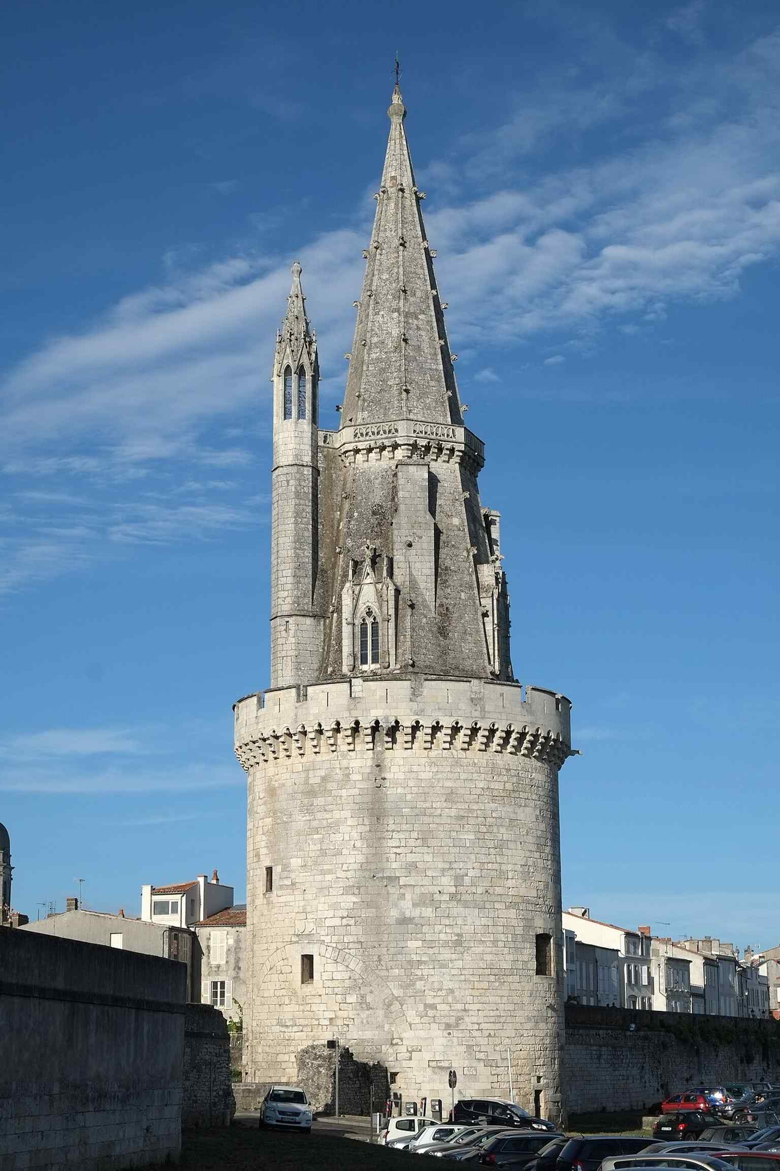 The tower rising above the waterfront, useful for showing how it stands at the edge of the historic harbor.