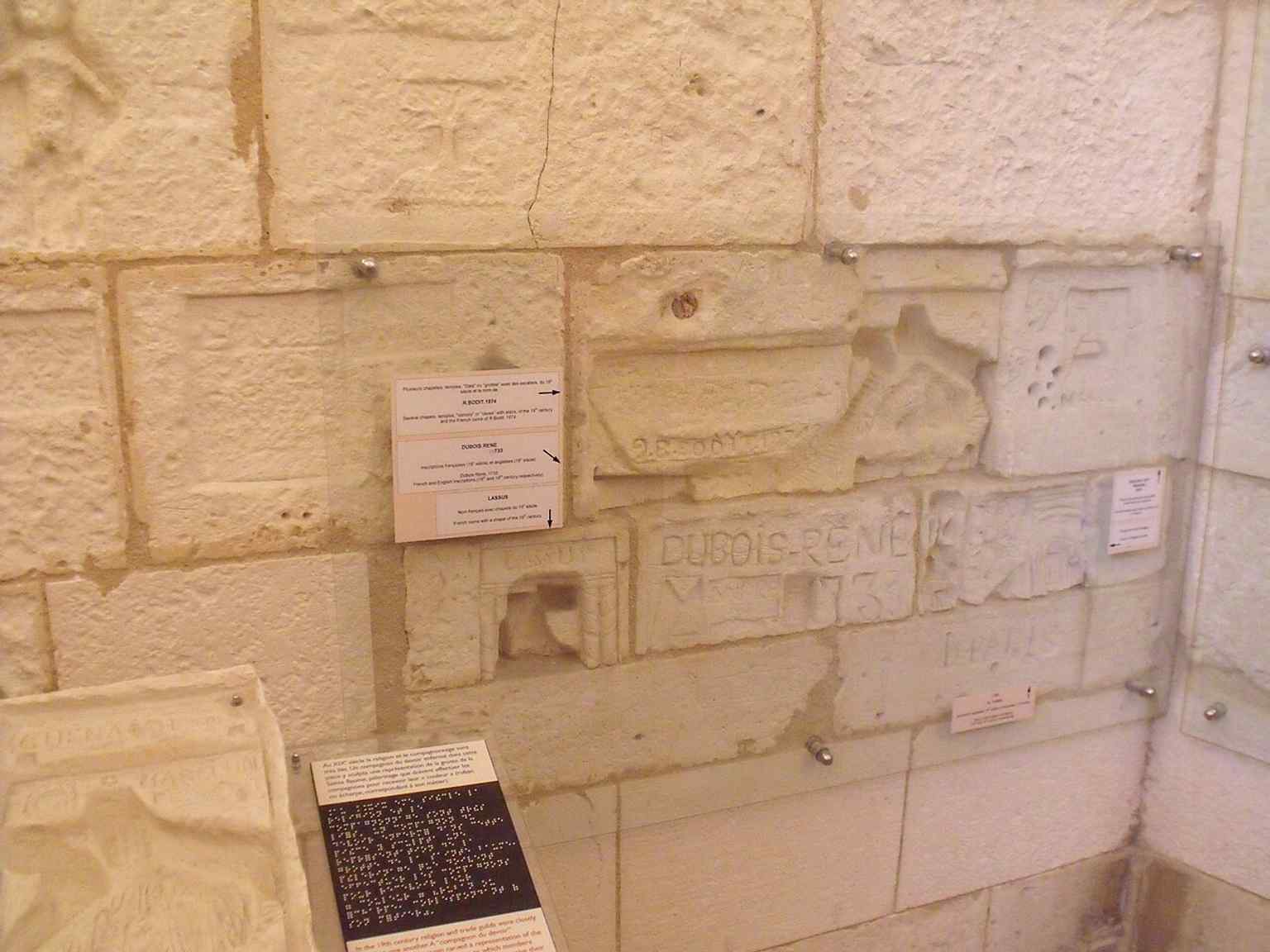One of the tower’s graffiti-filled interior walls, where prisoners recorded ships, names, and memories in the stone.