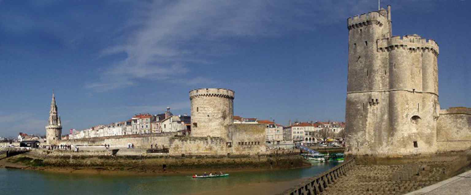 The famous trio of La Rochelle towers together — Lantern Tower, Chain Tower, and Saint-Nicolas Tower — as medieval seafront defenses.