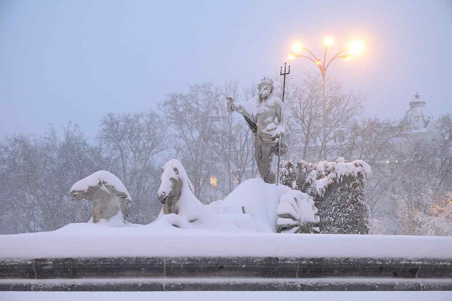 Neptuno under snow during Storm Filomena in 2021 — a dramatic modern scene that transforms the fountain into a city landmark in winter.