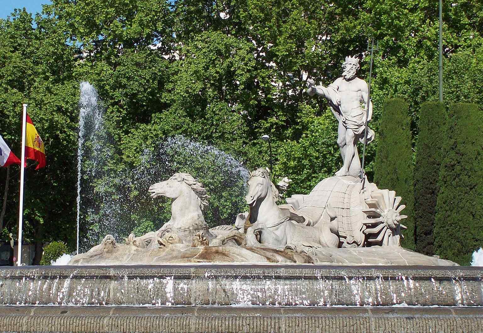 A close, clear view of the marble sculpture, letting you read the god’s pose and the carriage group carved around him.