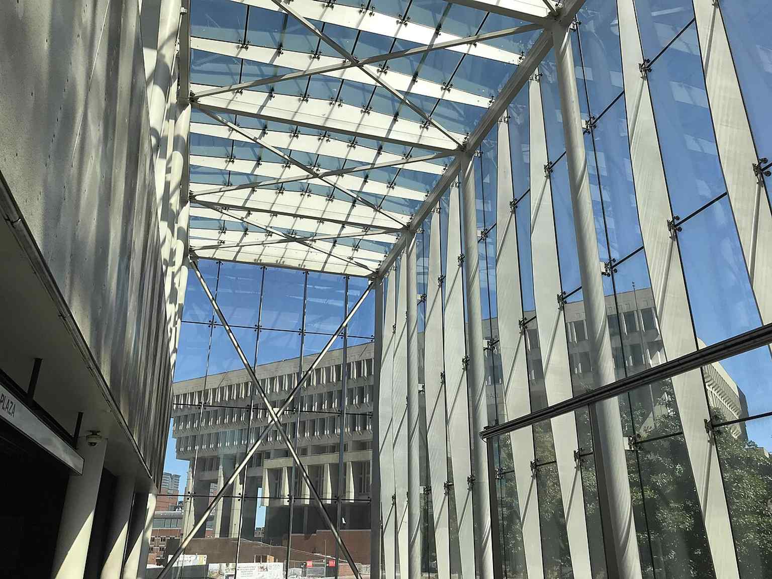 The new glass headhouse rising from City Hall Plaza — the 2016 rebuild replaced the old bunker-like entrance with this lighter, fully accessible entrance.