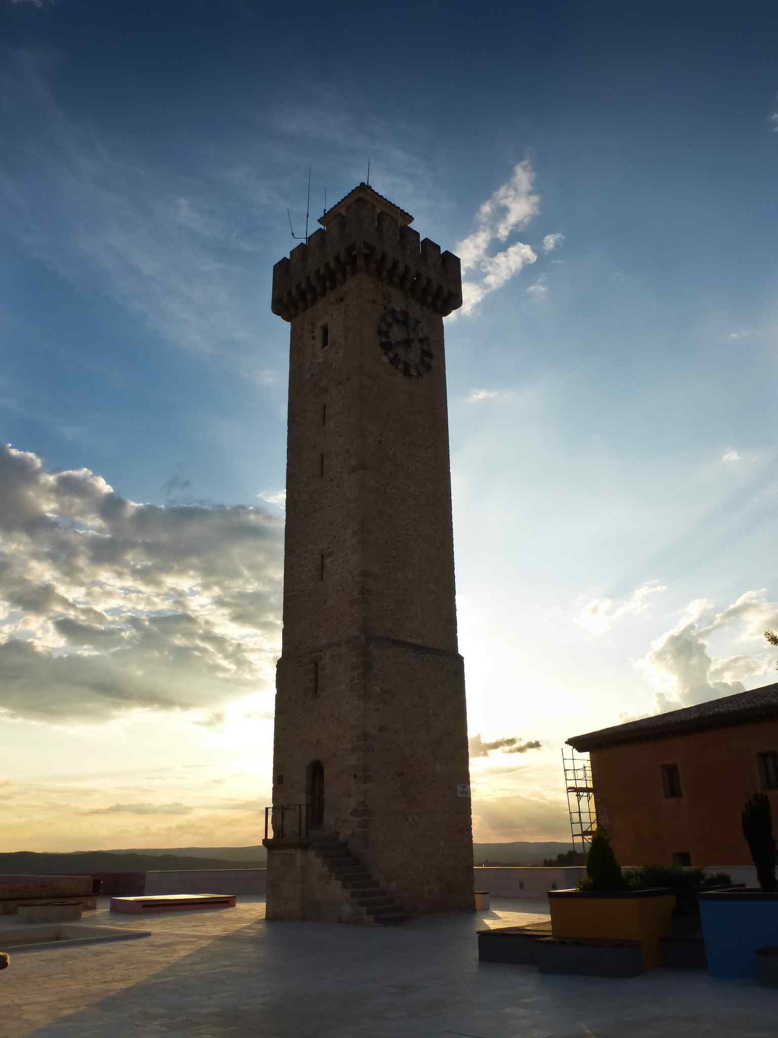 This ground-level view highlights the tower's current stonework, a stark contrast to the rich, colorful Neo-Mudéjar plaster decorations that adorned it from Fernando Alcántara's 1926 reform until 1970.